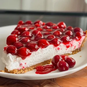 Delicious no-bake cherry cheesecake with a slice removed, showcasing creamy filling and a cherry topping.